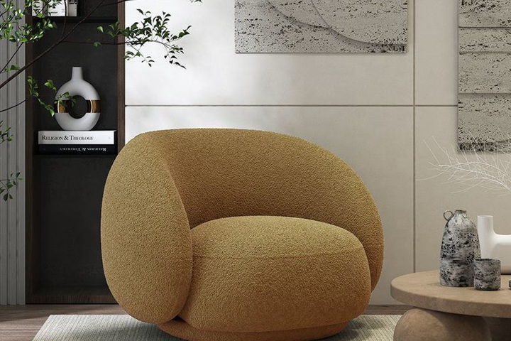 The Camilla chair — a rounded swivel lounge chair in ochre bouclé