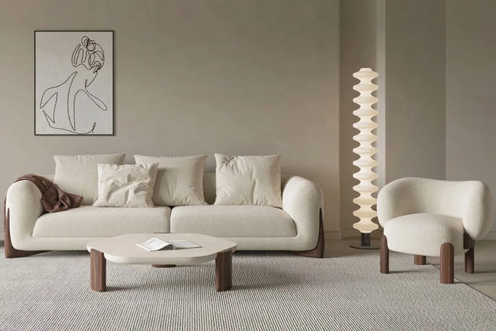 The Lucia sofa — a softly rounded three-seat sofa in ivory bouclé on solid timber feet