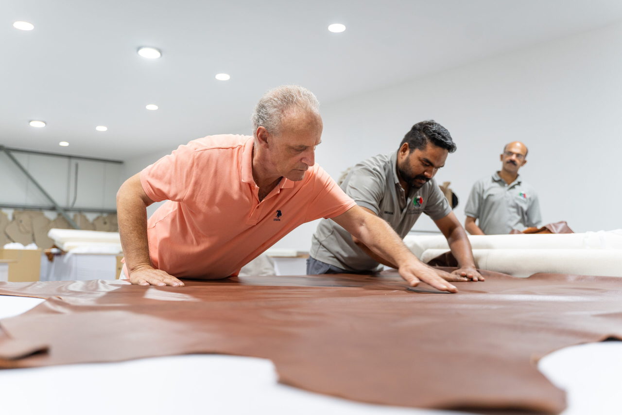 Roberto Pascalli and the FlorenStyle workshop team examining a leather hide across the design table